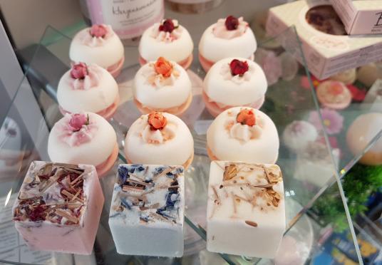 Cremebad in Form von Badepralinen auf Basis von Kakaobutter, Bio-Sheabutter und wertvollen Ölen mit verschiedenen Dekoren und Blüten. 